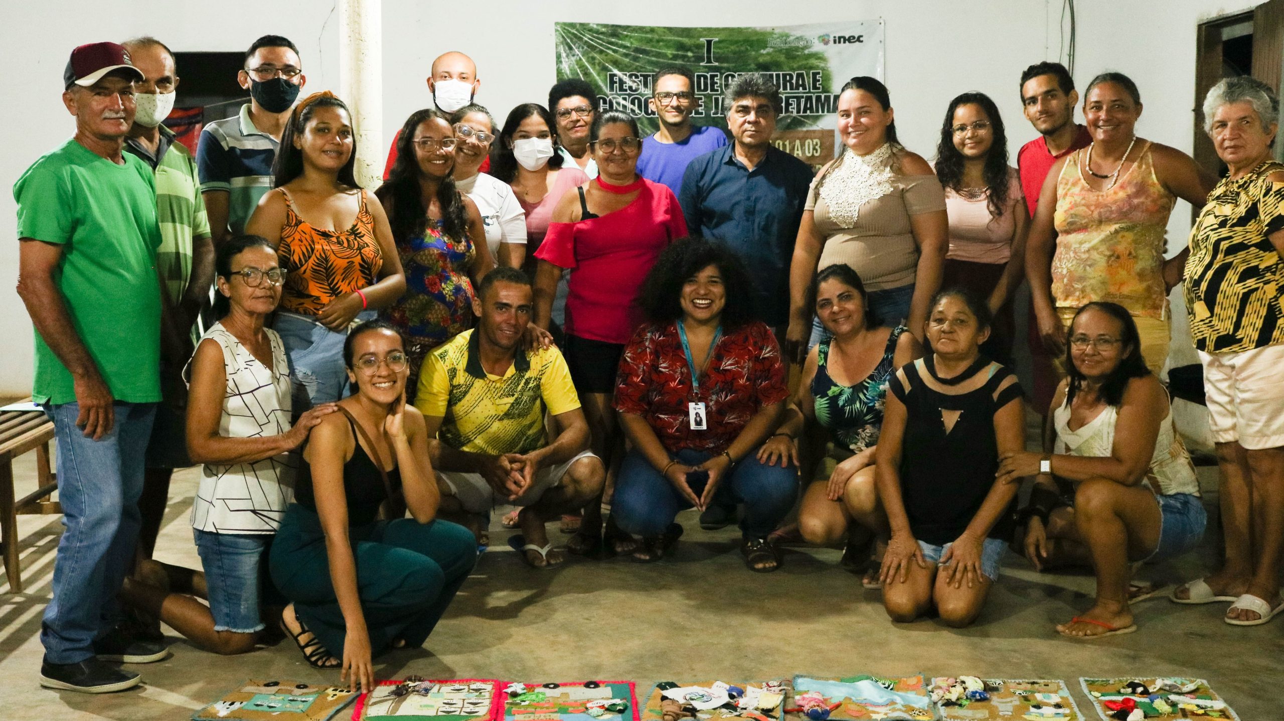 Na imagem tem dezenas de pessoas dispostas em pé e sentadas ao fim da última reunião do cultura em comunidade no território alagamar