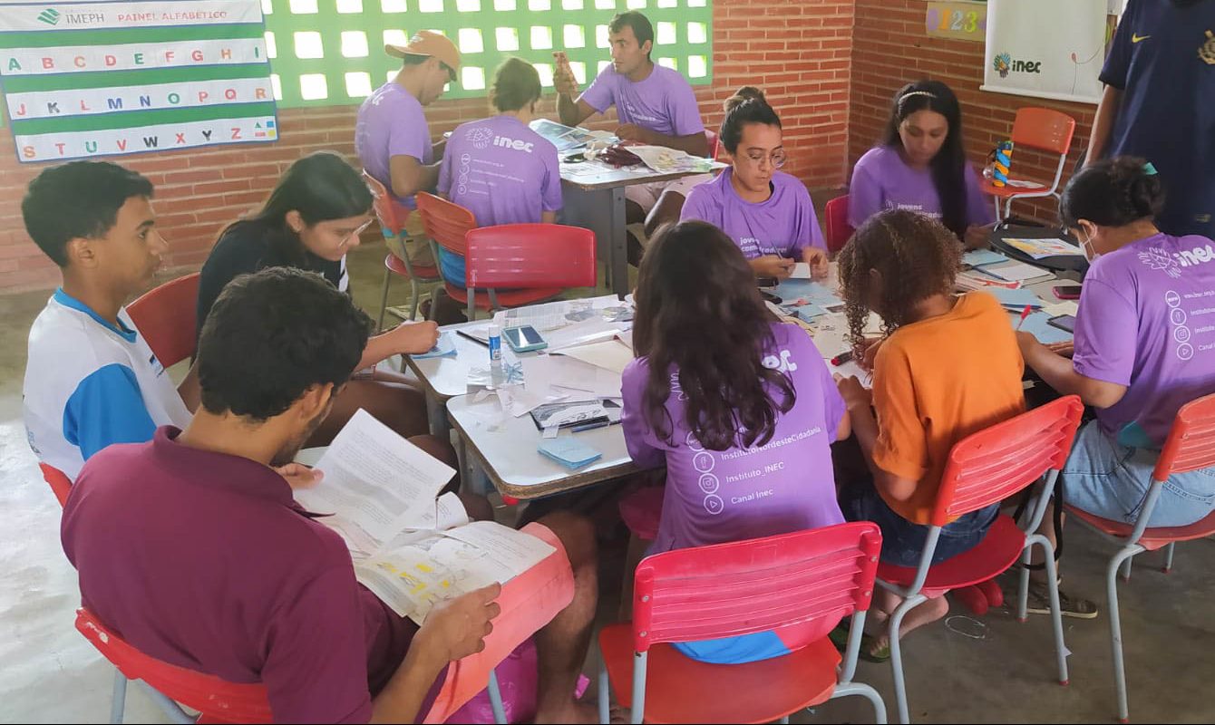 Na foto, pouco mais de uma dezena de jovens, todos sentados, praticam tarefas práticas da oficina dos Jovens Comunicadores em Jaguaretama