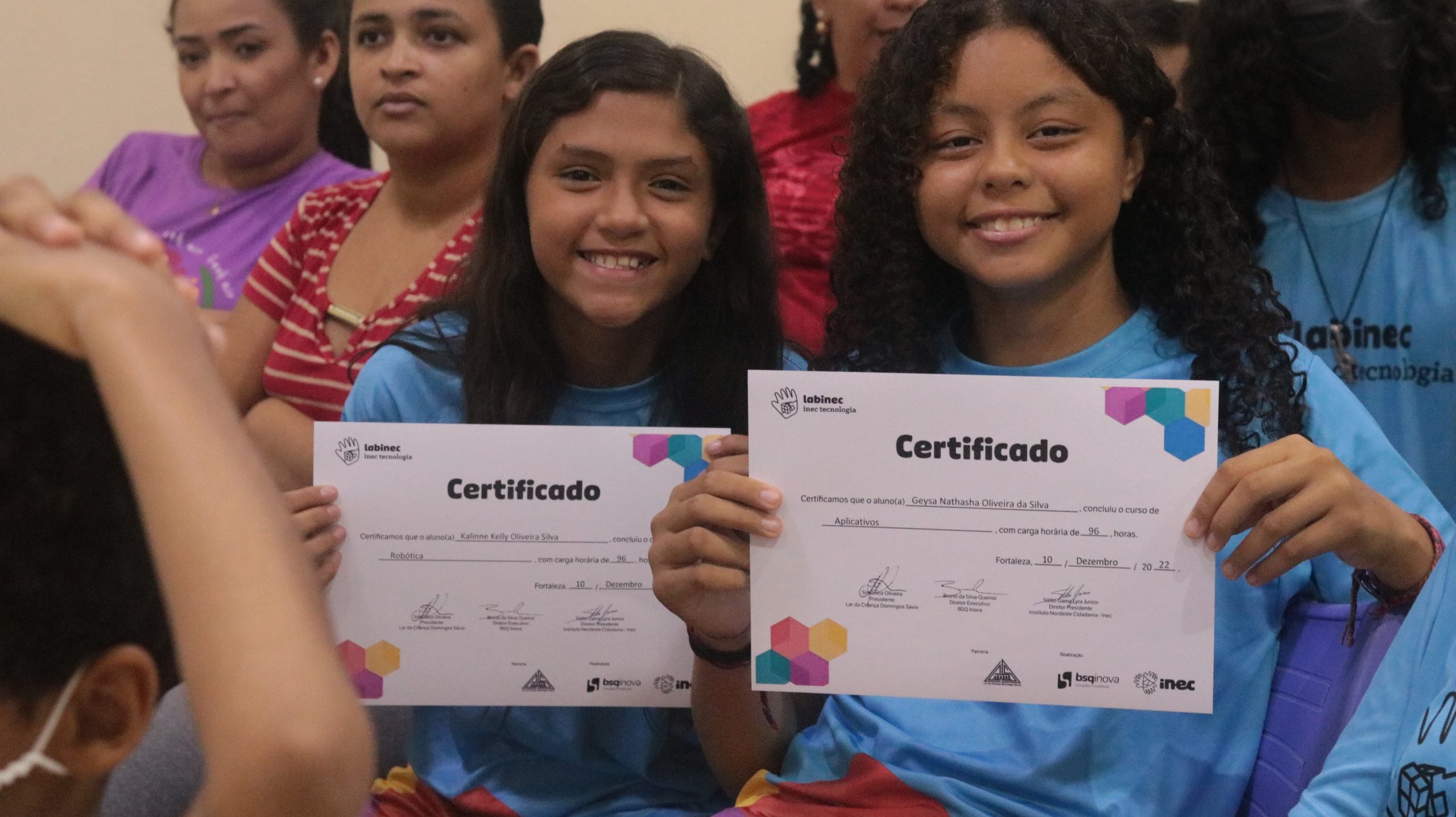 A imagem mostra duas meninas segurando o certificado de conclusão do labinec