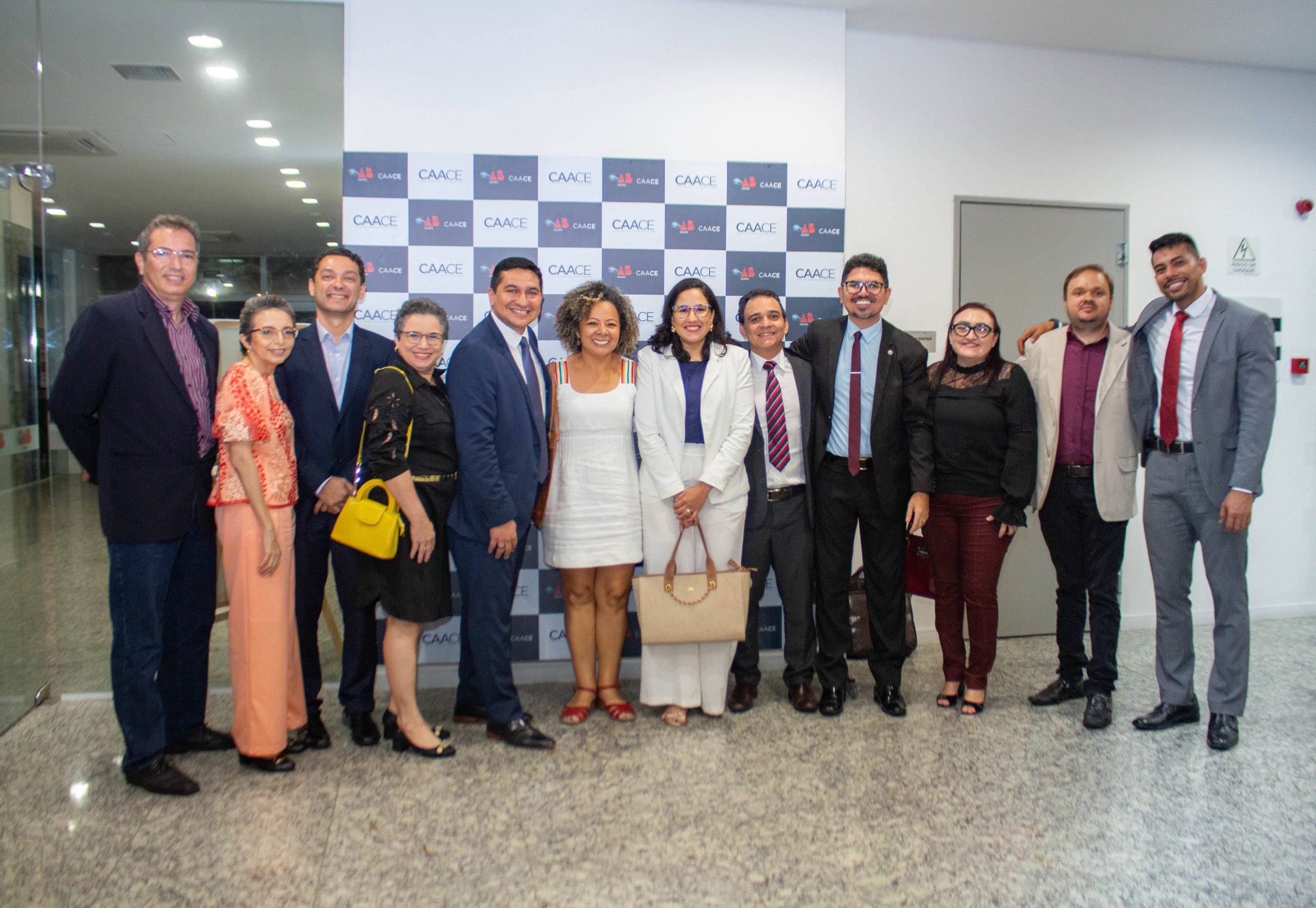 A imagem mostra vários representantes de entidades do terceiro setor cearense na frente de um painel do evento